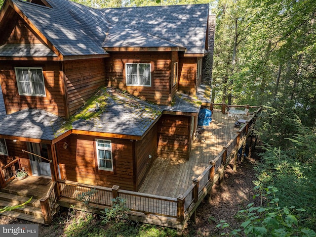 rear view of property featuring a wooden deck