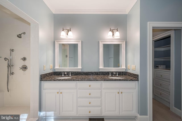 bathroom featuring a tile shower, ornamental molding, and vanity