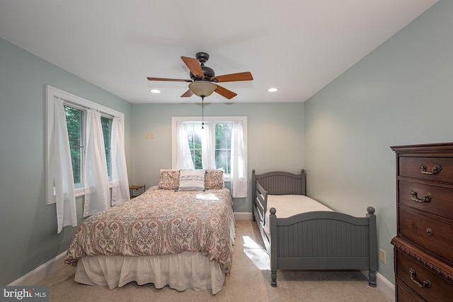 carpeted bedroom with multiple windows and ceiling fan