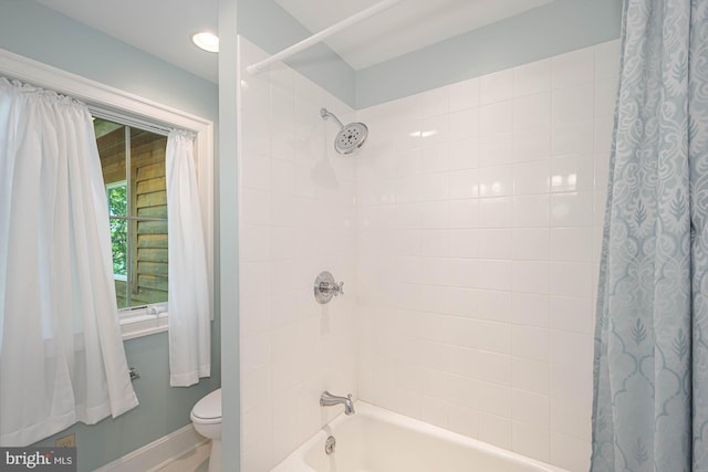 bathroom featuring shower / bath combo with shower curtain and toilet