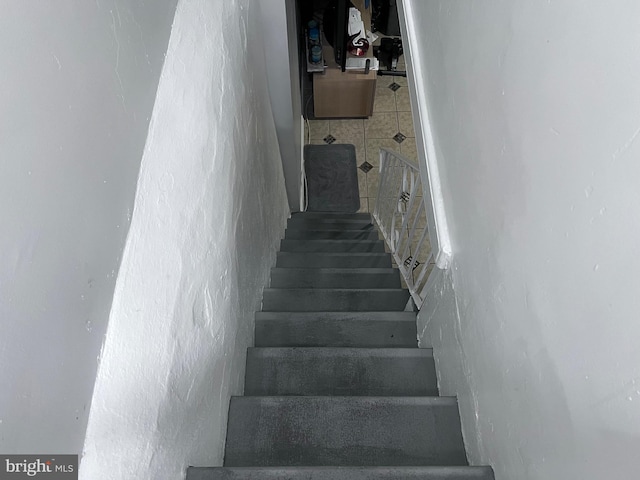 staircase featuring tile patterned floors