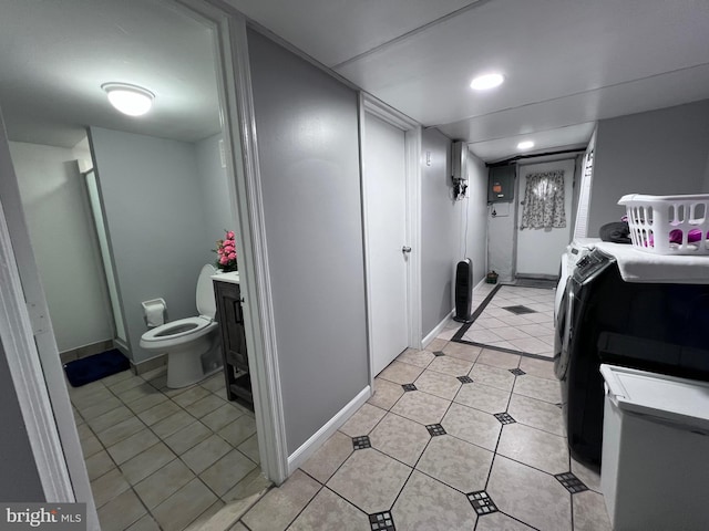 clothes washing area with washer and clothes dryer and light tile patterned floors