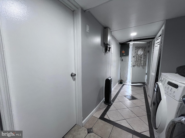 hall with light tile patterned floors, electric panel, and washing machine and dryer