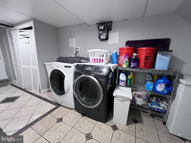 clothes washing area with light tile patterned floors and washing machine and dryer