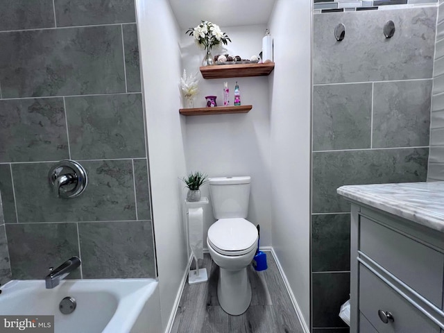 full bathroom with tiled shower / bath combo, vanity, toilet, and hardwood / wood-style flooring