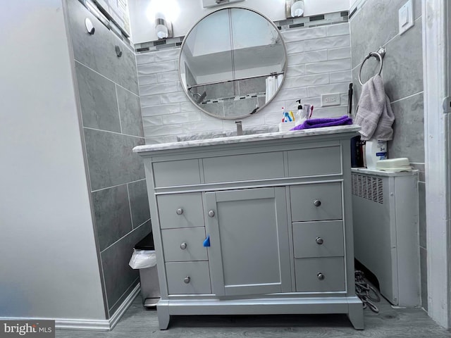 bathroom with vanity and tile walls