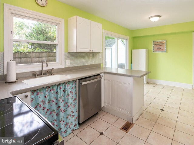 kitchen with light tile patterned flooring, sink, white cabinetry, dishwasher, and electric stove