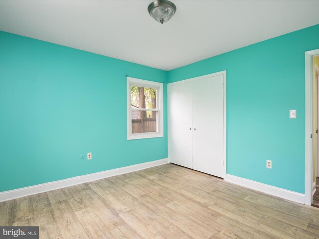 unfurnished bedroom featuring a closet and light wood-type flooring