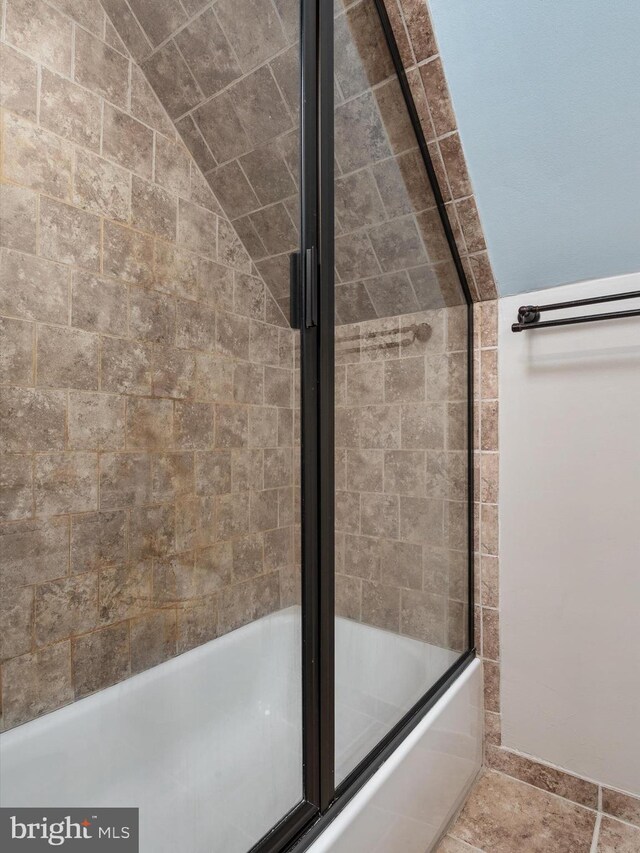 bathroom with bath / shower combo with glass door and lofted ceiling