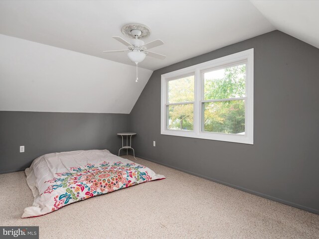 bedroom featuring ceiling fan, carpet flooring, and vaulted ceiling