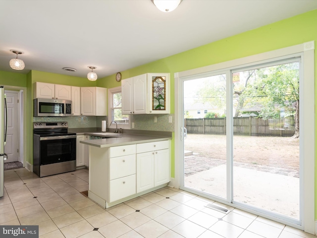 kitchen with stainless steel appliances, white cabinetry, sink, and decorative backsplash