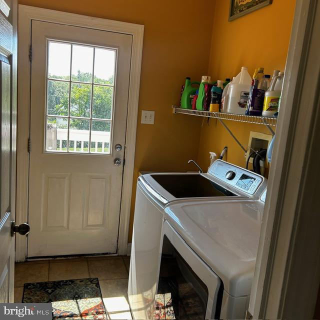 washroom with washer and dryer and light tile patterned floors