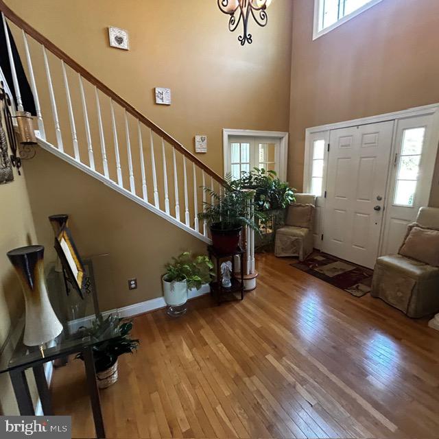 entrance foyer featuring a towering ceiling and hardwood / wood-style flooring