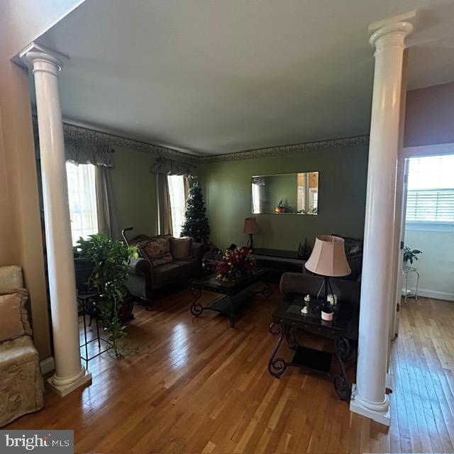 living room featuring wood-type flooring and ornate columns