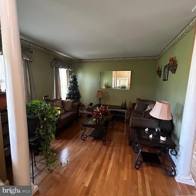 living room featuring hardwood / wood-style flooring and decorative columns