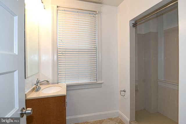 bathroom with tile patterned flooring, vanity, and a tile shower