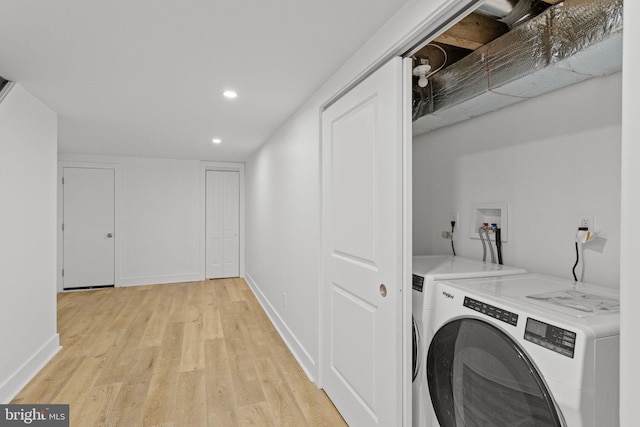 washroom featuring light hardwood / wood-style flooring and washer and clothes dryer