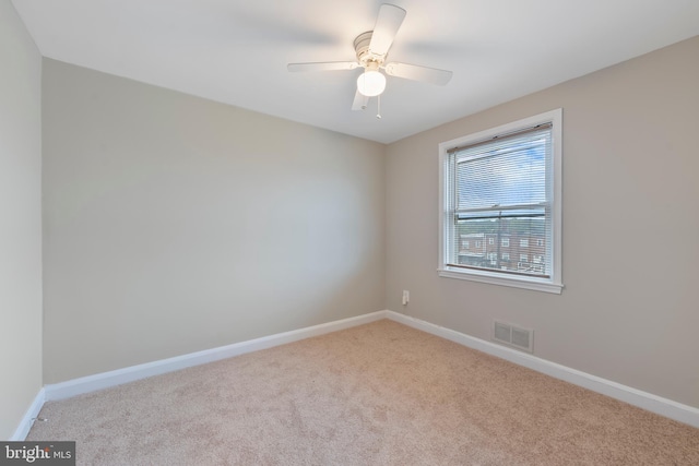 unfurnished room featuring a ceiling fan, carpet flooring, baseboards, and visible vents