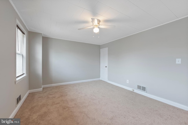 empty room with visible vents, light carpet, baseboards, and a ceiling fan