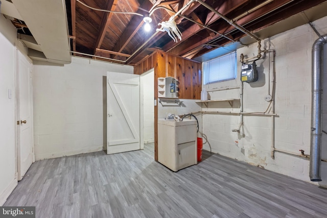 basement with washer / clothes dryer, wood finished floors, and concrete block wall
