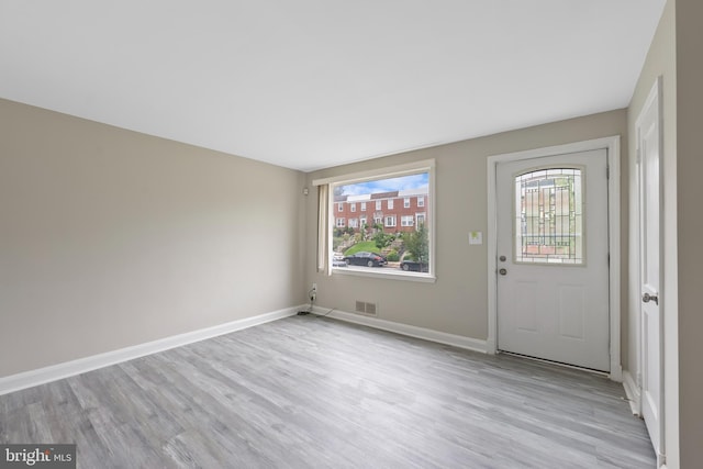 interior space featuring light wood-type flooring, visible vents, and baseboards