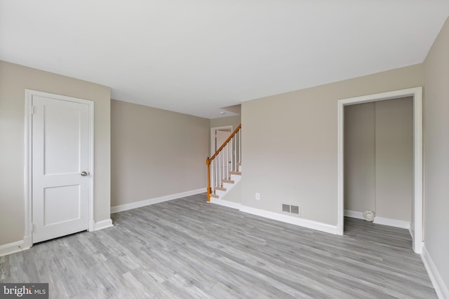 empty room featuring visible vents, baseboards, and stairs
