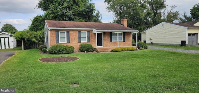 view of front facade featuring a porch, a shed, and a front yard