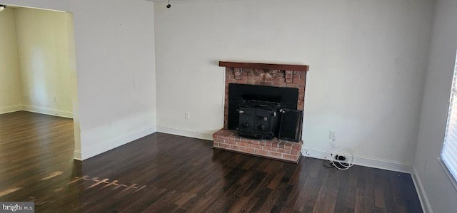 unfurnished living room with a wood stove and dark hardwood / wood-style flooring