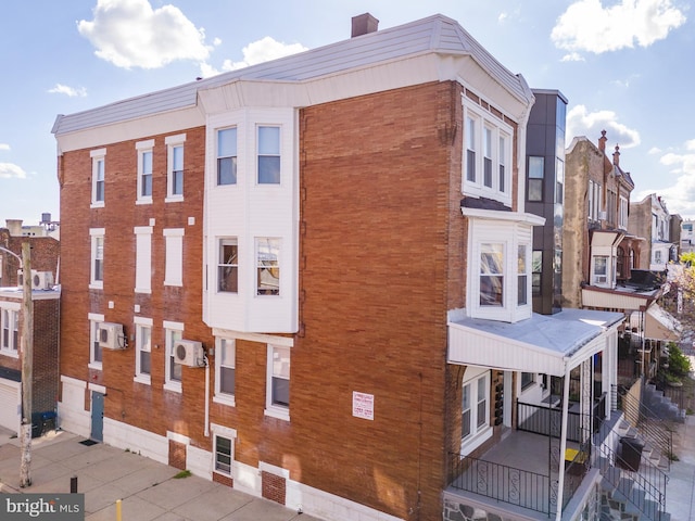 view of building exterior with a wall mounted AC