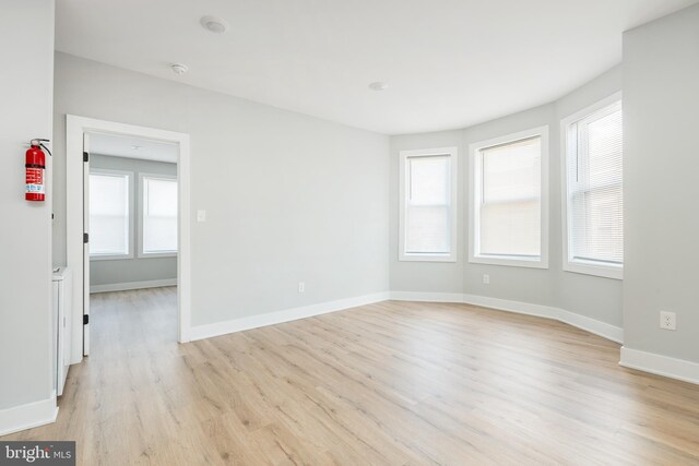 spare room with plenty of natural light and light hardwood / wood-style flooring