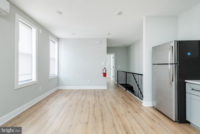 kitchen featuring plenty of natural light, stainless steel fridge, and light hardwood / wood-style floors