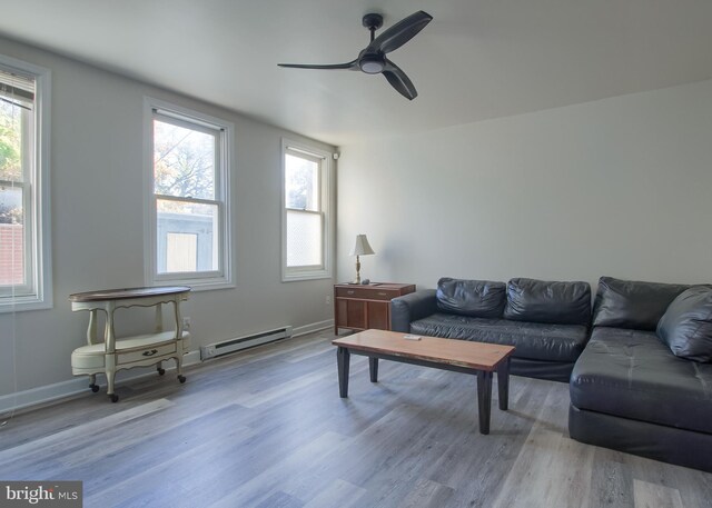 living room featuring a baseboard radiator, a wealth of natural light, light hardwood / wood-style floors, and ceiling fan