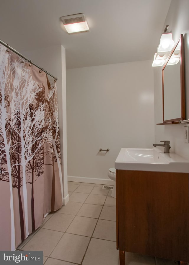 bathroom with tile patterned flooring, vanity, and toilet