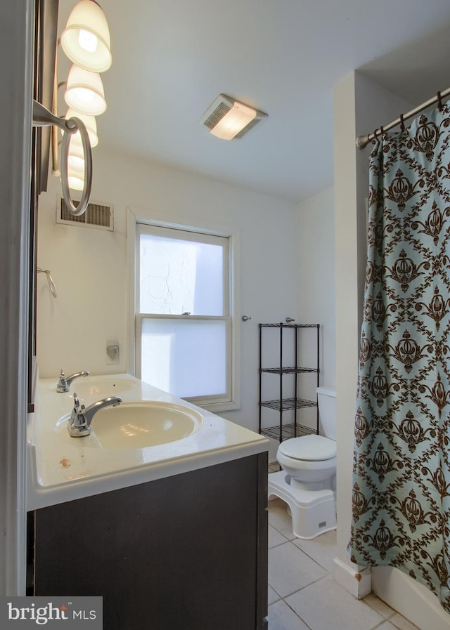 bathroom with toilet, vanity, tile patterned flooring, and walk in shower