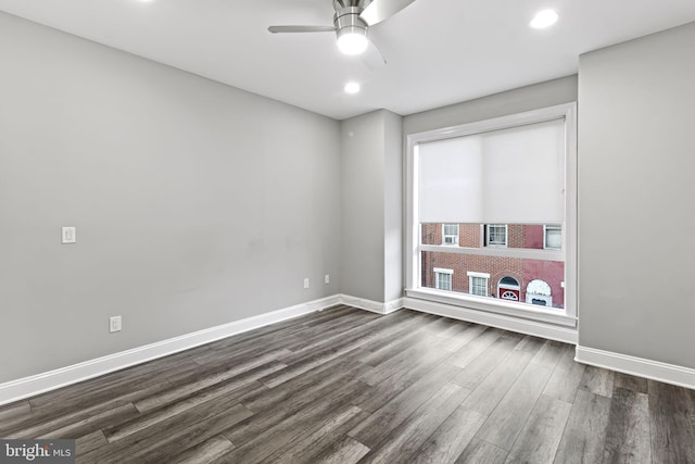 empty room with ceiling fan and dark hardwood / wood-style flooring