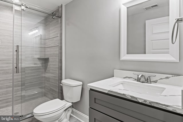 bathroom featuring vanity, toilet, and an enclosed shower