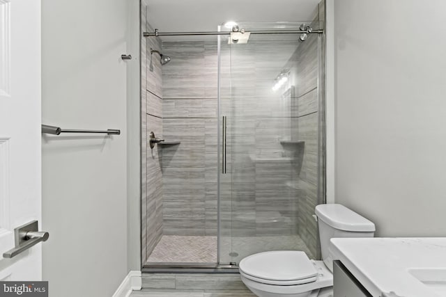 bathroom featuring vanity, toilet, hardwood / wood-style flooring, and an enclosed shower