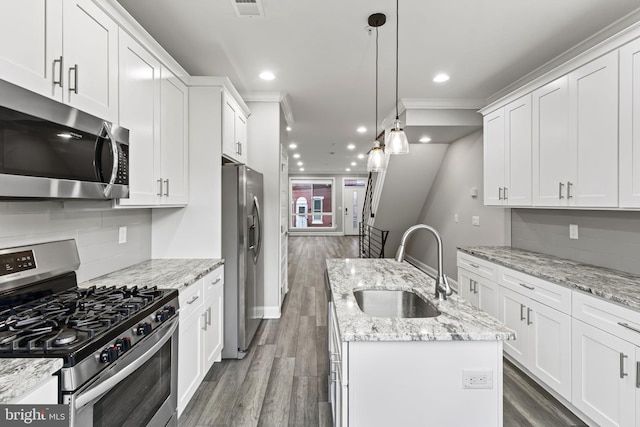 kitchen with white cabinetry, stainless steel appliances, sink, dark hardwood / wood-style floors, and a center island with sink