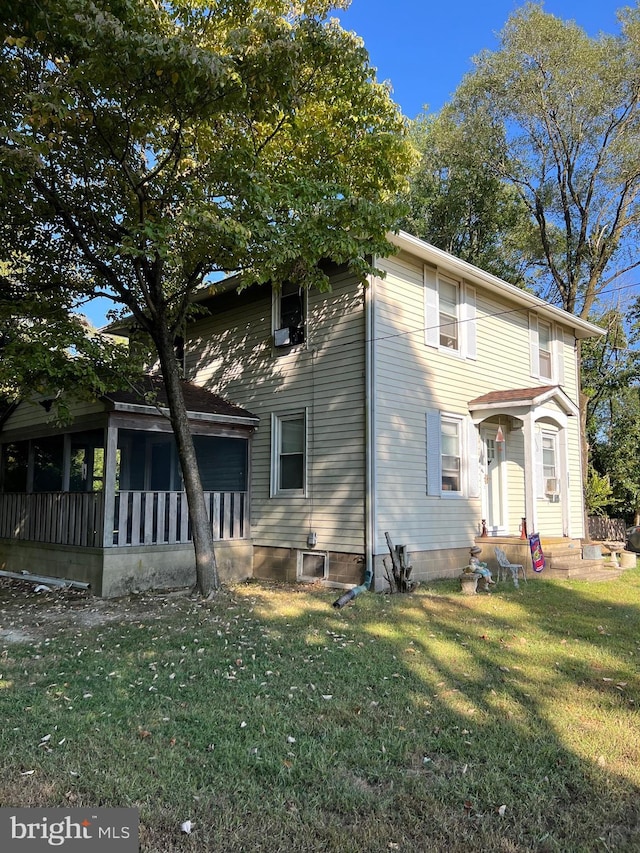 view of front facade with a sunroom and a front lawn