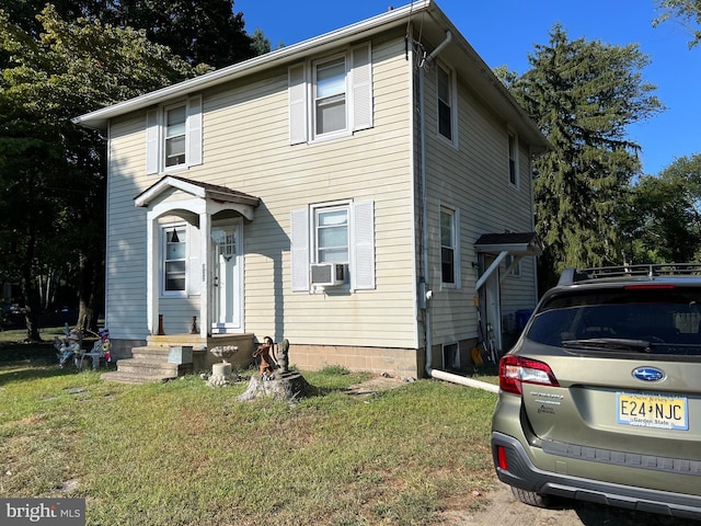 front facade featuring a front yard and cooling unit