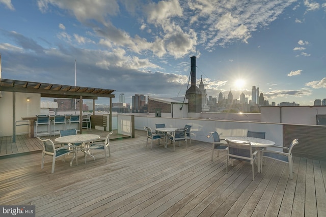 deck featuring outdoor dining area and a city view