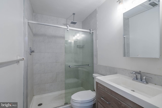 bathroom featuring a stall shower, vanity, and toilet