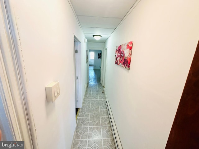 hallway with a baseboard heating unit and light tile patterned floors