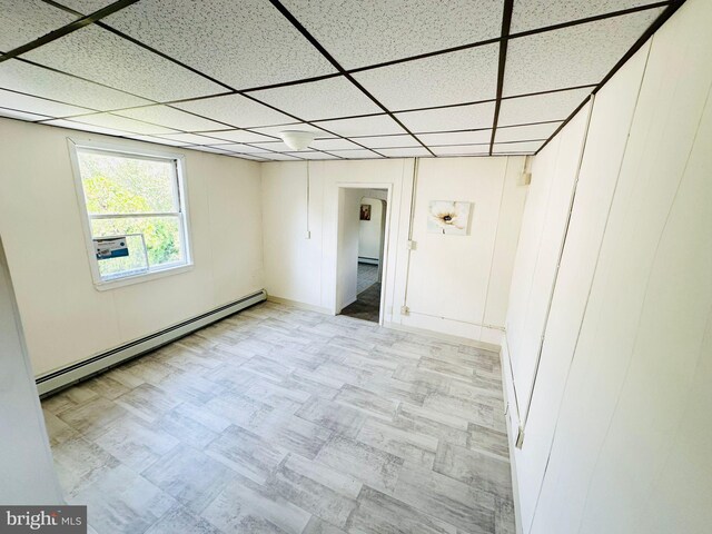 interior space with baseboard heating and a drop ceiling