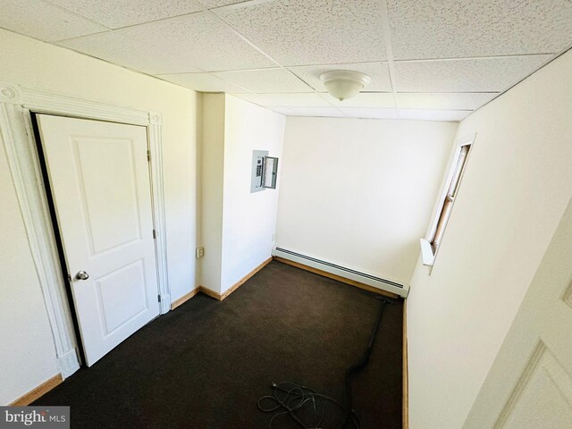 carpeted empty room with electric panel, a baseboard radiator, and a paneled ceiling