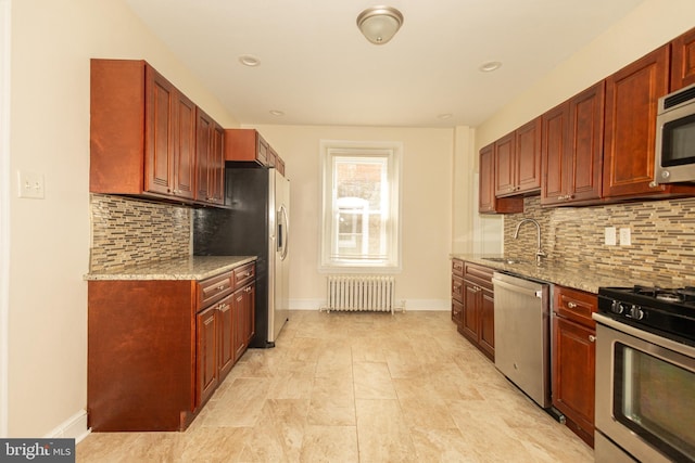 kitchen featuring sink, radiator heating unit, appliances with stainless steel finishes, and tasteful backsplash