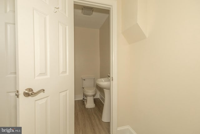 bathroom with toilet and wood-type flooring