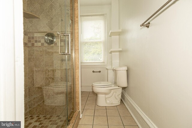 bathroom featuring tile patterned flooring, a shower with shower door, and toilet