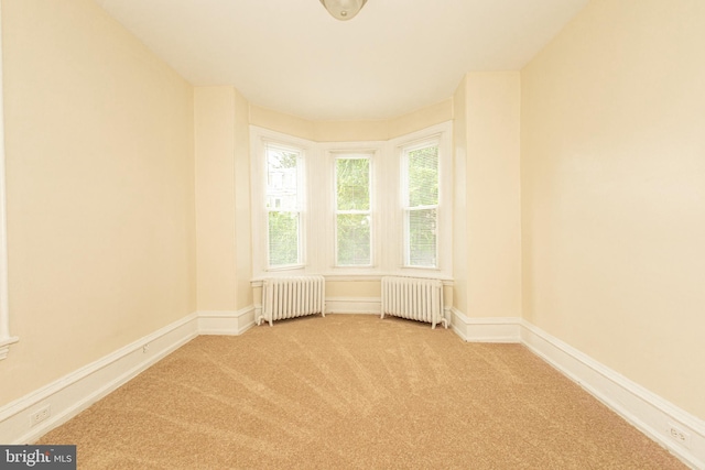 carpeted spare room featuring radiator