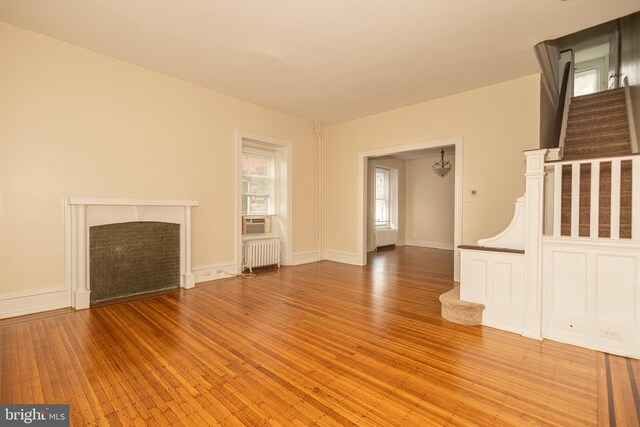 unfurnished living room featuring hardwood / wood-style flooring and radiator